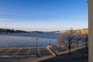Kleine Eisschollen schwimmen auf dem Fjord, rechts sieht man das Stockholmer Rathaus