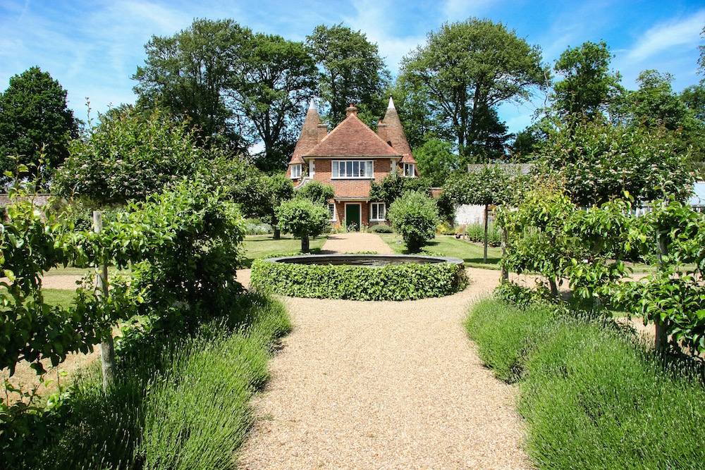 Obstbäume in der Mitte es Walled Garden, dahiner das Haus mit den Hopfendarren