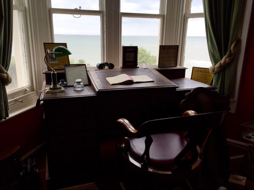Ein dunkler Schreibtisch, mit Sicht auf die Nordsee, direkt vor dem Fenster. 