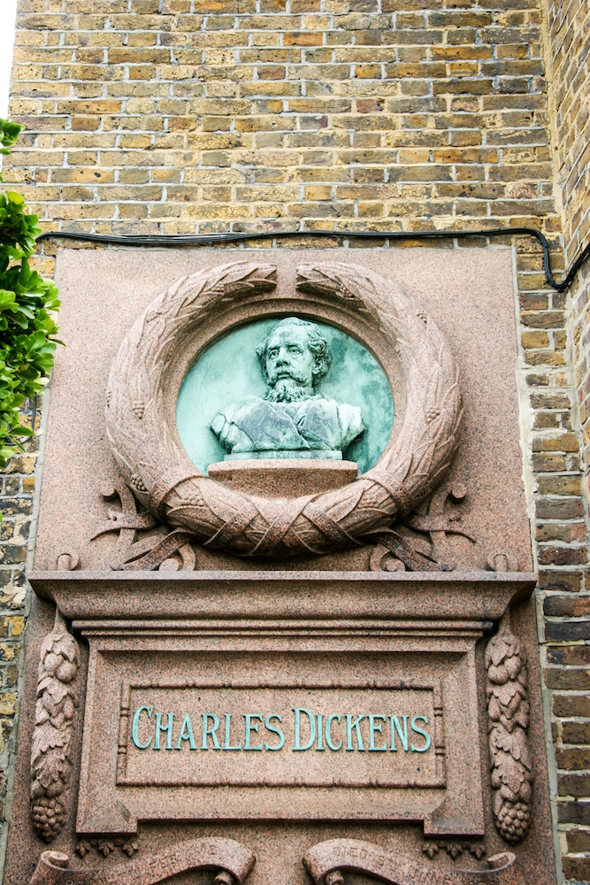 Eine Büste von Charles Dickens an der Hauswand