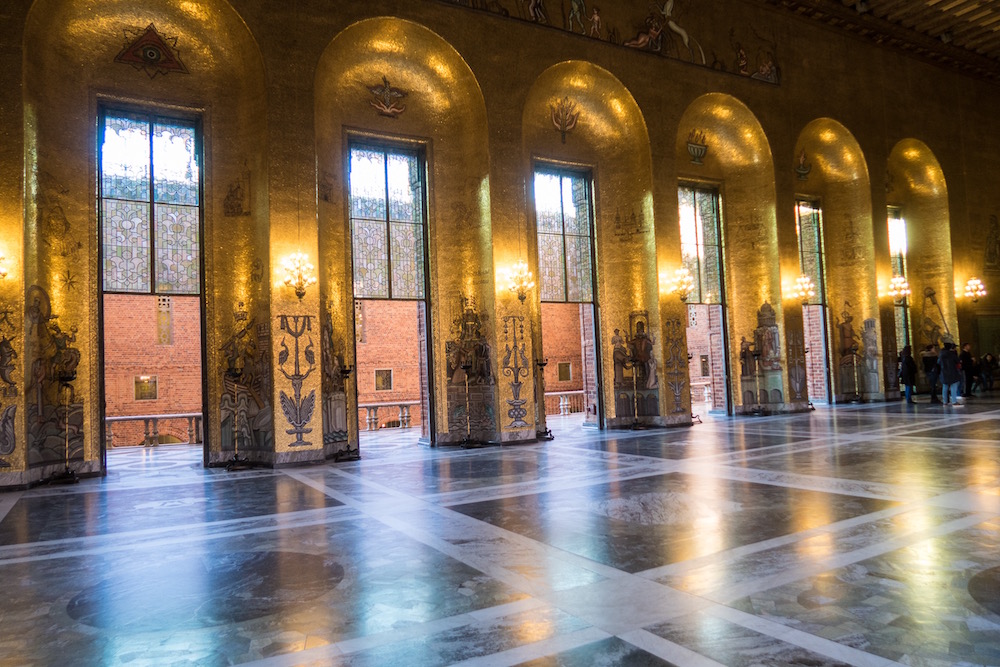 Ein großer Saal. Die Wände sind komplett mit goldenen Mosaiksteinen verziert.