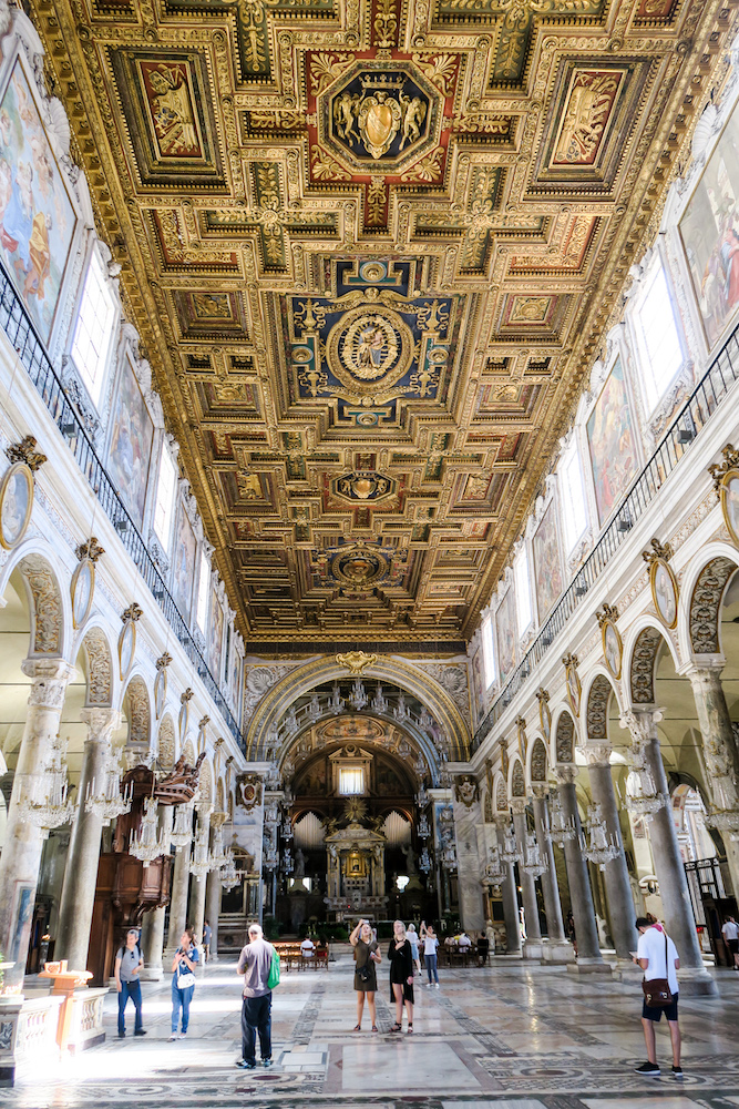 Innenraum einer Kirche mit goldverzierten, kastenförmigen Decken