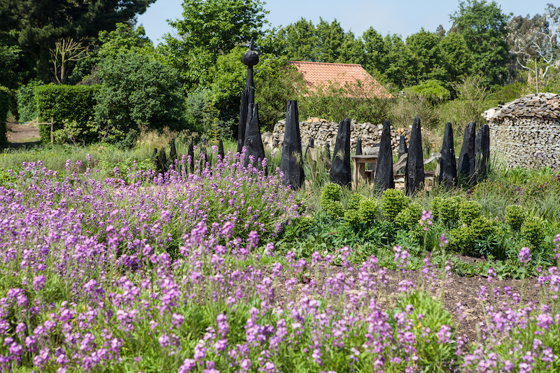 Hortus Spiralis, der Spiralen Garten. Die schwarzen Stelen sind eigentlich  die Baumstämme gefällte Monterey Pines. Diese wurden mit der Zeit zu groß und spendeten zu viel Schatten. Sie wurden geschwärzt und als Spirale in die Erde gesetzt.